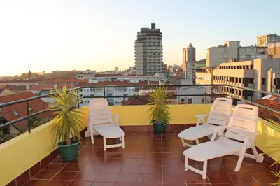 a group of white chairs sitting on a roof at Santa Clara Porto in Porto