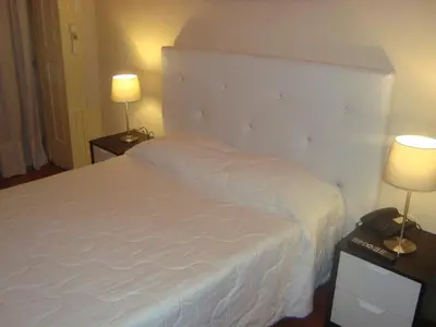 a bedroom with a large white bed with two lamps at Santa Clara Porto in Porto