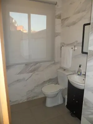 a white bathroom with a toilet and a sink at Guest house D. Filipe I in Porto