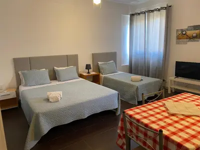 a hotel room with two beds and a television at Guest house D. Filipe I in Porto