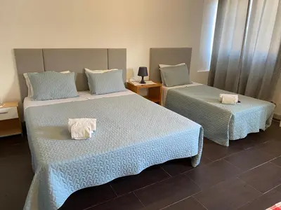 two beds in a hotel room with towels on them at Guest house D. Filipe I in Porto