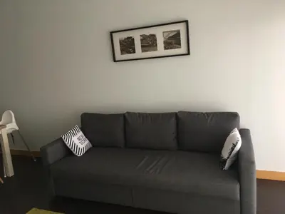 a gray couch in a living room with a picture on the wall at Porta do Sol in Porto