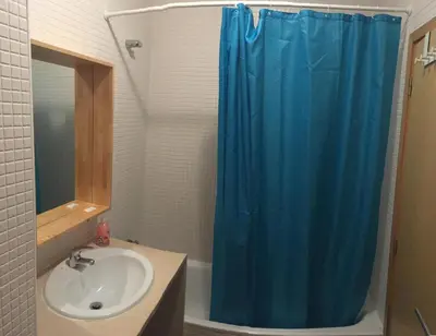 a bathroom with a blue shower curtain and a sink at Porta do Sol in Porto