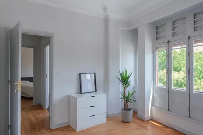 a white room with a tv on a dresser at Baixa24 - Downtown Bliss w/ Amazing Natural Light in Porto