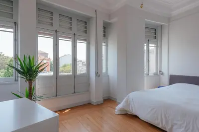 a white bedroom with a bed and windows at Baixa24 - Downtown Bliss w/ Amazing Natural Light in Porto