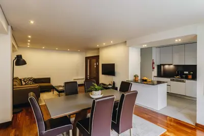 a living room and kitchen with a table and chairs at Premium Apartment with Private Terrace & Garage in Porto