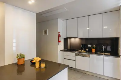 a kitchen with white cabinets and a black counter top at Premium Apartment with Private Terrace & Garage in Porto