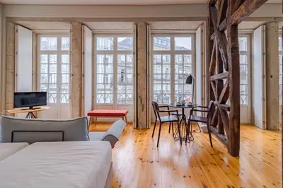 a living room with a bed and a table with chairs at YOUROPO - City Center Ribeira Porto in Porto
