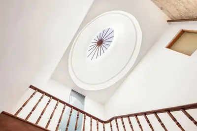a spiral staircase with a clock on the ceiling at Flowerstreet 54 in Porto