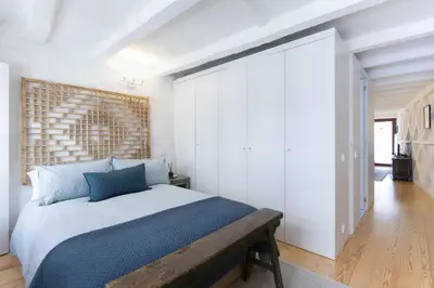 a bedroom with a large bed with a wooden headboard at VIVA Caldeireiros Porto Old Town in Porto