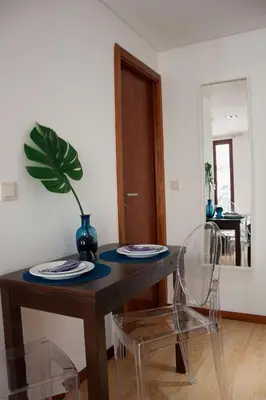 a dining room table with a plant on top of it at Nations Porto - Studios & Suites in Porto