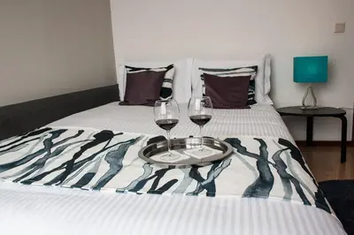 a bed with two glasses of wine on it at Nations Porto - Studios & Suites in Porto