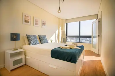 a bedroom with a bed and a large window at Green Suite in Porto