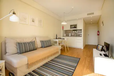 a living room with a couch and a kitchen at Green Suite in Porto