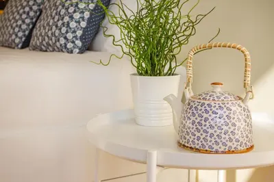 a white table with a tea kettle and a plant at Green Suite in Porto