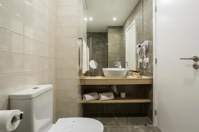 a bathroom with a white toilet and a sink at Predicados do Douro Palace in Porto