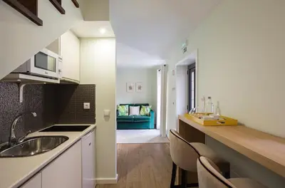 a kitchen with a sink and a couch in a room at Predicados do Douro Palace in Porto