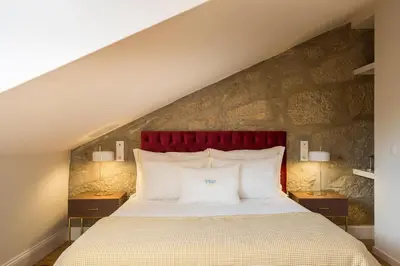 a bedroom with a large bed with a red headboard at Predicados do Douro Palace in Porto