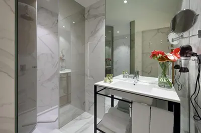 a bathroom with a sink and a vase of flowers at Eurostars Porto Centro in Porto