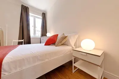 a bedroom with a white bed and a table with a lamp at Sleep in Centre in Porto