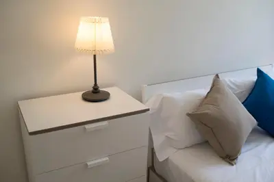 a bed with a table with a lamp on it at Sleep in Centre Downtown in Porto