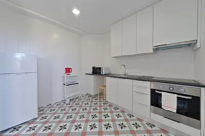 a kitchen with white appliances and a tile floor at Sleep in Centre Downtown in Porto