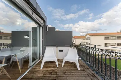a balcony with white chairs and a table at GuestReady - Cosy studio in the heart of Porto in Porto