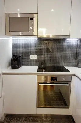 a kitchen with white cabinets and a stove and a microwave at Lux Downtown in Porto