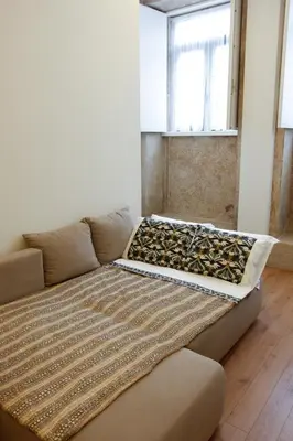 a couch in a living room with a bed at Lux Downtown in Porto