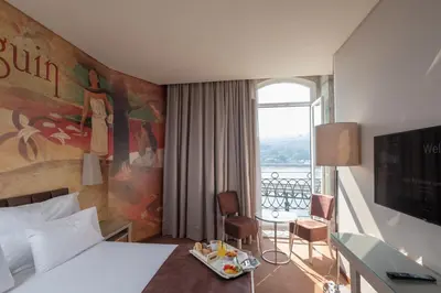 a hotel room with a bed and a balcony at Vila Gale Porto Ribeira in Porto