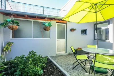 a patio with a table and chairs and a yellow umbrella at Apartamento Garden Avenue in Porto