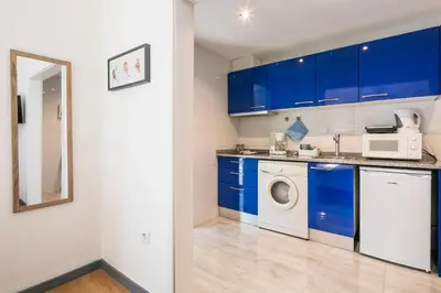 a kitchen with blue cabinets and a washing machine at Apartamento Garden Avenue in Porto