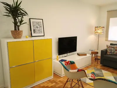 a living room with a yellow cabinet and a tv at Always Porto in Vila Nova de Gaia