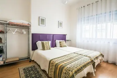 a bedroom with a large bed with a purple headboard at Apartamento Purple Room in Porto