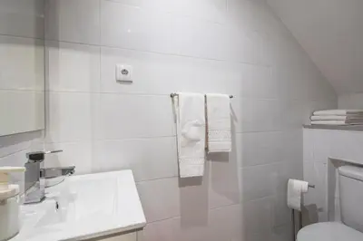 a bathroom with a sink and a toilet and towels at Apartamento Purple Room in Porto