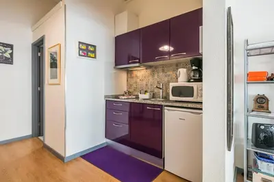 a kitchen with purple cabinets and a microwave at Apartamento Purple Room in Porto