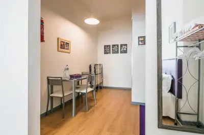 a dining room with a table and chairs and a mirror at Apartamento Purple Room in Porto