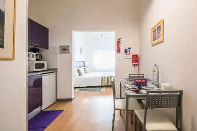 a kitchen and a dining room with a table with chairs at Apartamento Purple Room in Porto