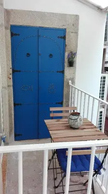a table and a blue chest of draws on a porch at The Blue and White Porto House in Porto