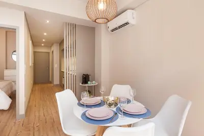 a dining room with a table and white chairs at Sendme2Portugal: Santa Catarina in Porto