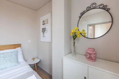 a bedroom with a bed and a mirror on a wall at Sendme2Portugal: Santa Catarina in Porto