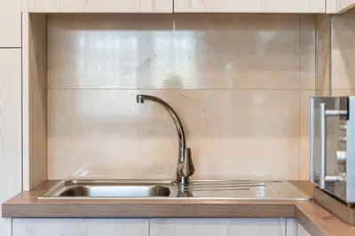 a stainless steel kitchen sink with a faucet at GuestReady - Sound of Nature - T1 Boavista in Porto