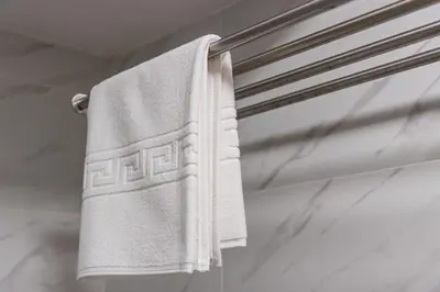 a white towel hanging on a towel rack in a bathroom at GuestReady - Sound of Nature - T1 Boavista in Porto
