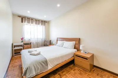 a bedroom with a large bed and a table at GuestReady - Sound of Nature - T1 Boavista in Porto