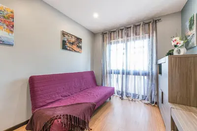 a living room with a purple couch in front of a window at GuestReady - Sound of Nature - T1 Boavista in Porto