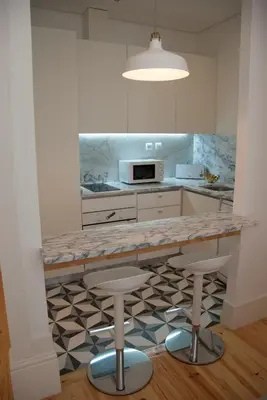 a kitchen with a counter and stools in it at OportoView Alegria Apartment in Porto