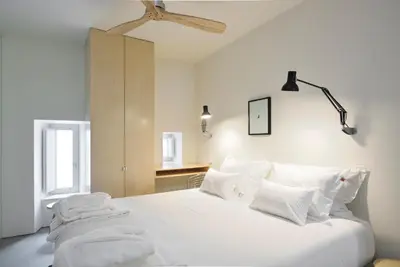 a bedroom with a white bed with white pillows at House of Artists in Porto