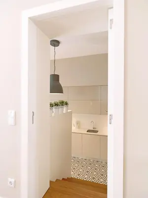 a kitchen with white cabinets and a black light fixture at FLH Porto Bright Flat in Porto