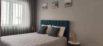 a bedroom with a bed with a blue headboard at Bessa Apartment in Porto