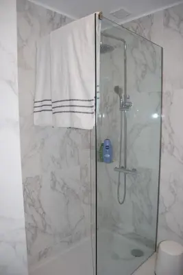 a bathroom with a shower with a white towel at Bessa Apartment in Porto